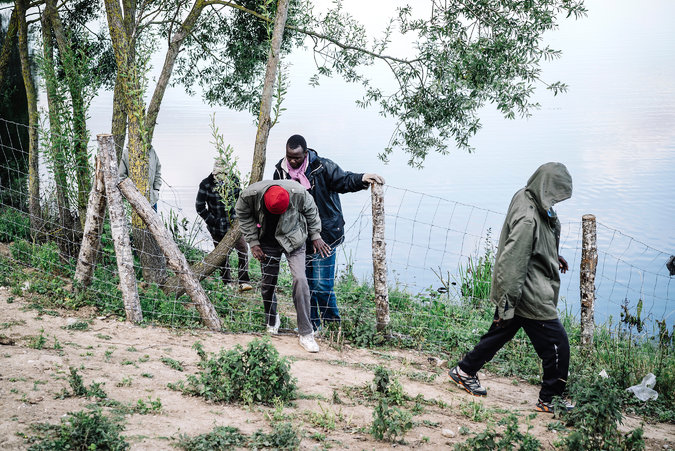 Migrants waited to try to board trains on Thursday on the French side of the Channel Tunnel in Calais. Credit Tom Jamieson for The New York Times