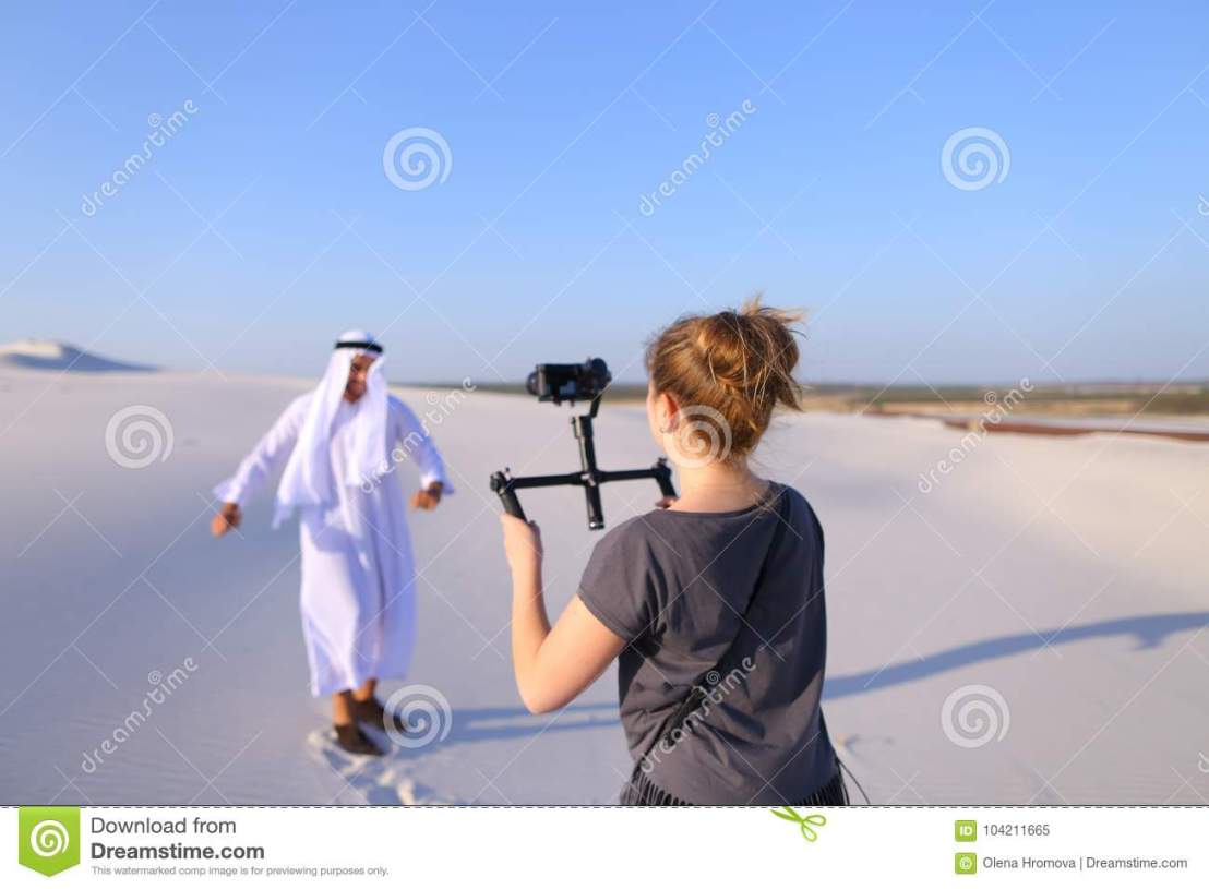 girl-shoots-camera-dancing-muslim-man-spacious-desert-h-process-shooting-arab-guy-camera-young-women-holds-camera-104211665